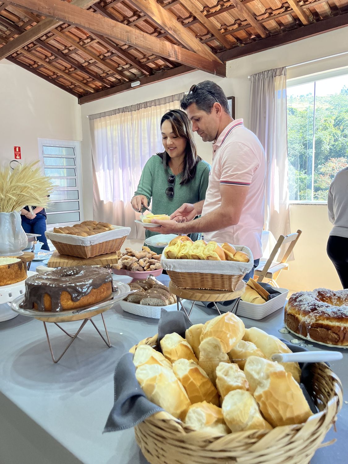 Hóspedes servindo o café da manhã no salão da pousada