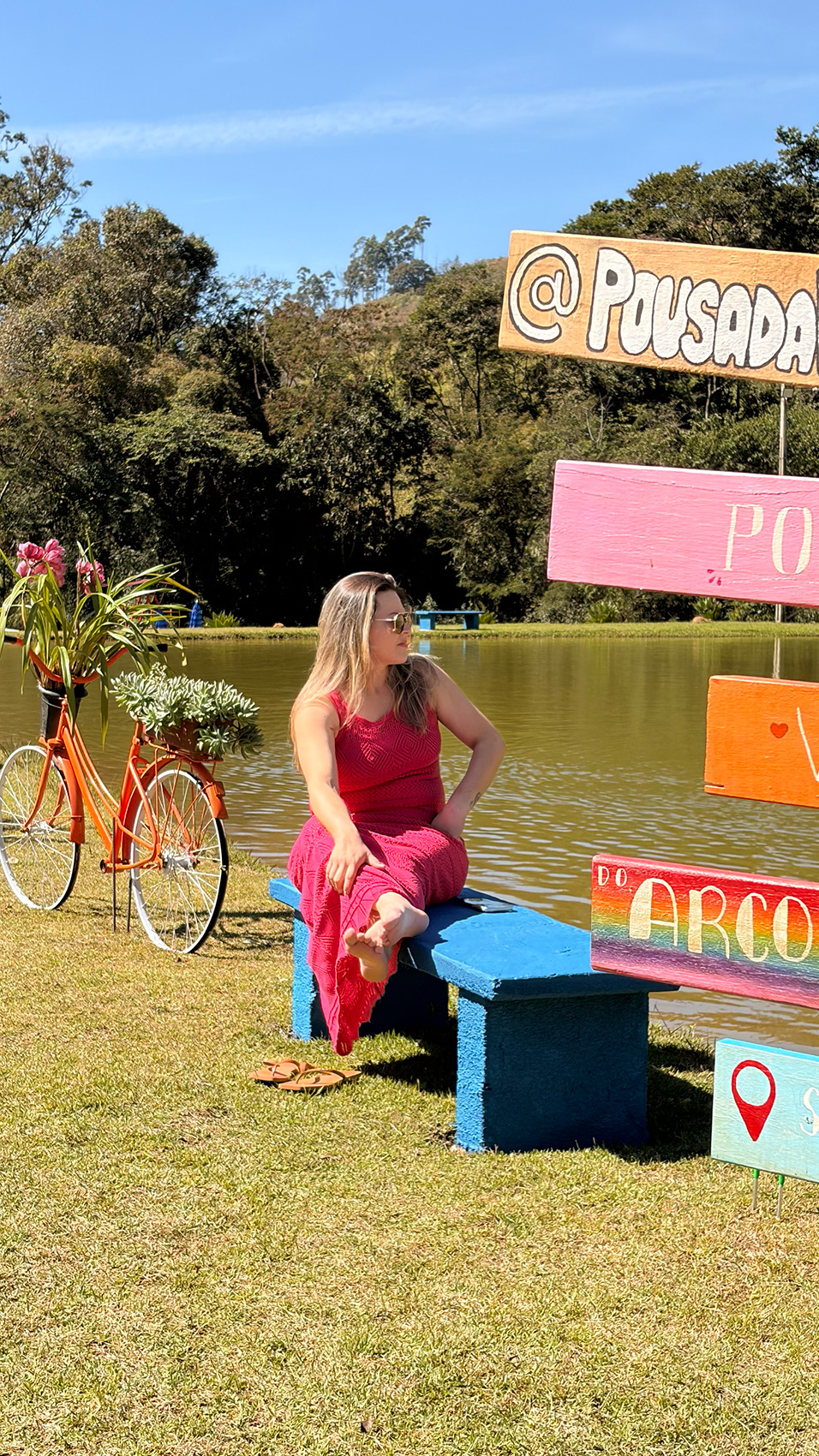 Lago da Pousada Vale do Arco Íris com bicicleta decorada e vista das montanhas de Serra Negra